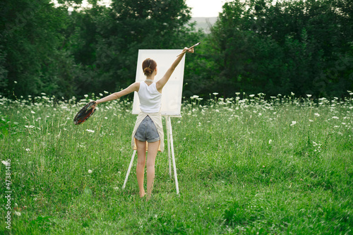 artist in nature painting a picture creative landscape back view