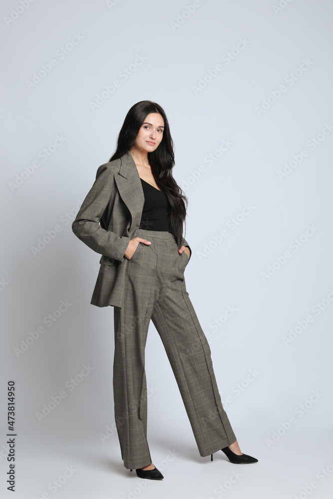 Full length portrait of beautiful woman in formal suit on light background. Business attire Full length portrait of beautiful woman in formal suit on light background. Business attire