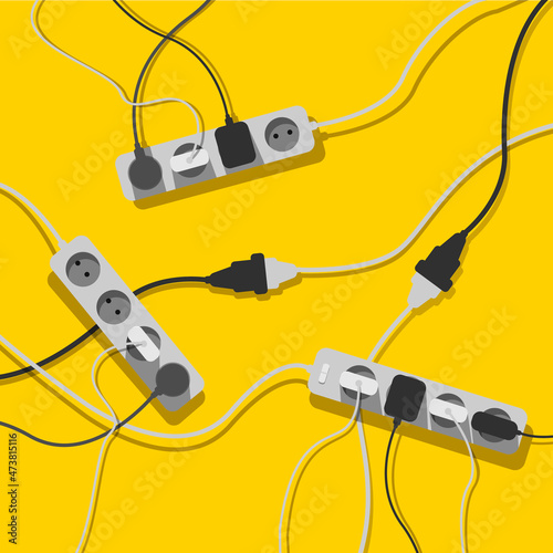 A mess of cables from several extension cords, electrical wires and chargers on a yellow background. Cable clutter. Cable management. 