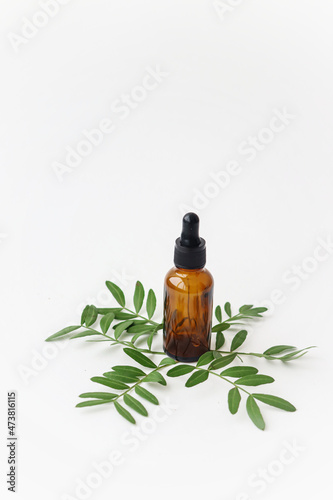 Fototapeta Naklejka Na Ścianę i Meble -  Cosmetic oil on a background of green leaves