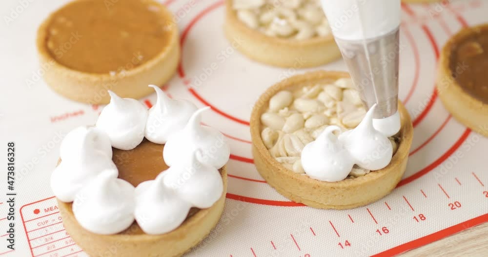Biscuit tartlet decorated chef with cream from pastry bag, close-up. Preparation of cake at home bakery with piping bag. Homemade pastry concept. Biscuit tartlet decorated chef with cream from pastry bag, close-up. Preparation of cake at home bakery with piping bag. Homemade pastry concept.