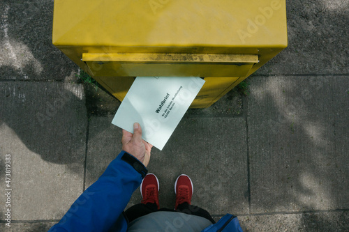 Man putting ballot letter in mailbox photo