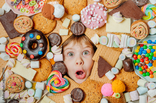 Slika na platnu Little girl lying under plenty of sweet foods