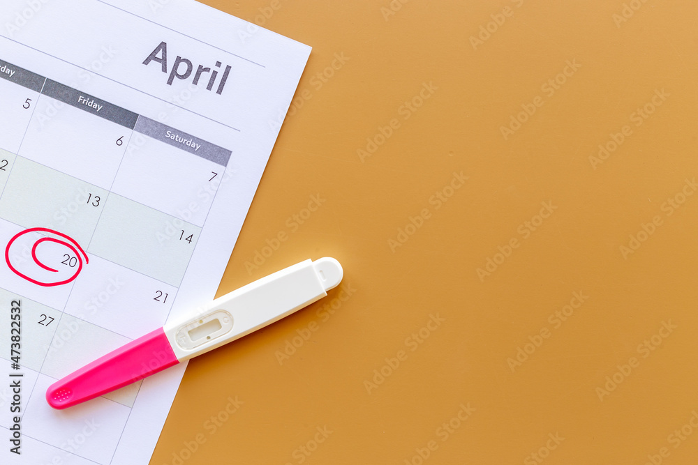 Calendar with pregnancy test, top view. Morherhood and pregnancy concept Calendar with pregnancy test, top view. Morherhood and pregnancy concept