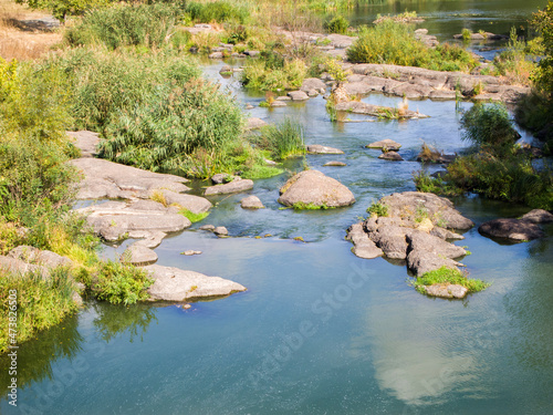 View of a calm river with rocky banks and rapids.