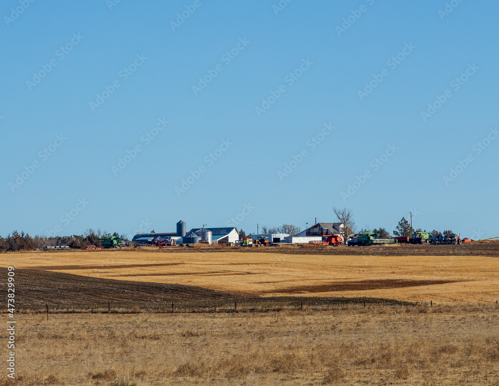 Obraz premium Beautiful Colorado landscape with a meadow, farm, trees, and Rocky Mountains in the distance