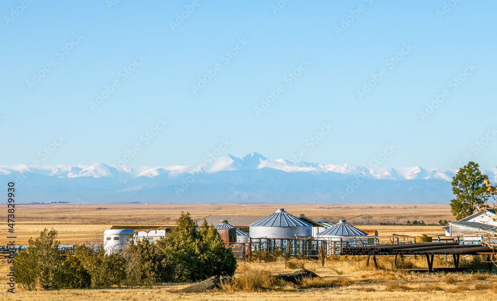 Beautiful Colorado landscape with a meadow, farm, trees, and Rocky Mountains in the distance Beautiful Colorado landscape with a meadow, farm, trees, and Rocky Mountains in the distance