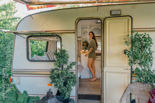 Smiling young woman seen through camper trailer door