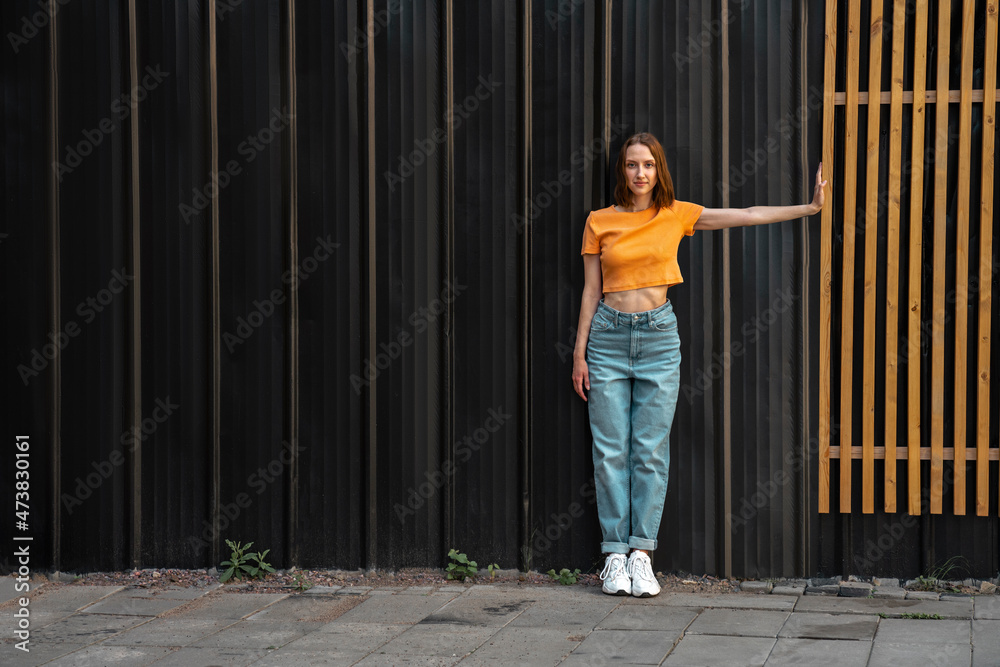 Woman stretching hand while standing on footpath Woman stretching hand while standing on footpath