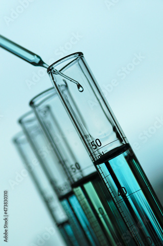Pipetting drop of liquid into graduated cylinder.