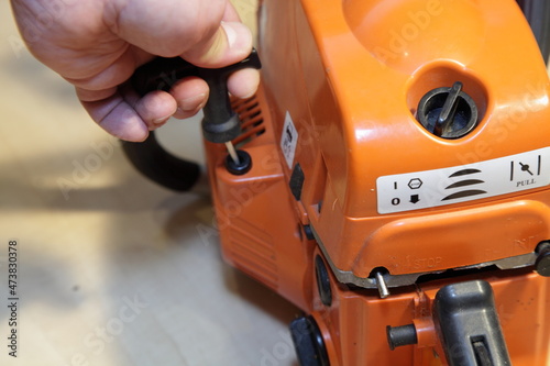 Tableau sur toile Chainsaw motor manual starter handle with a hand closeup - power tools motor lau