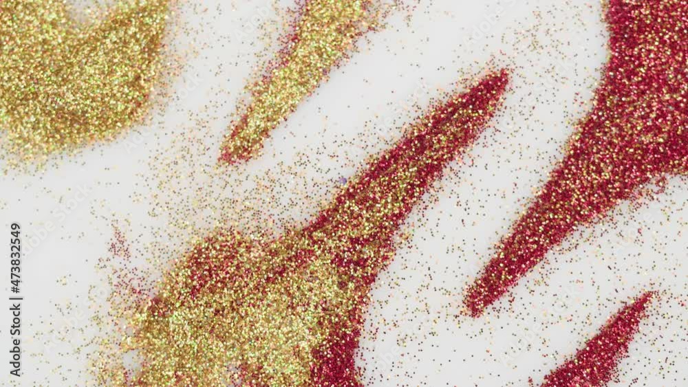Blowing gold and red glitter on white background, gloss golden powder close-up. Shining dust particles, blue shimmer. Makeup and beauty, decorative cosmetics concept. New year time. Blowing gold and red glitter on white background, gloss golden powder close-up. Shining dust particles, blue shimmer. Makeup and beauty, decorative cosmetics concept. New year time.