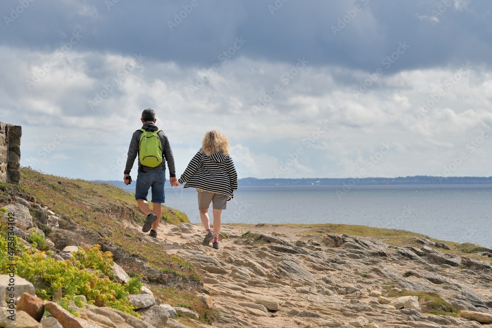 Fototapeta premium People,walking along the wild coast at the Quiberion peninsula in Brittany France