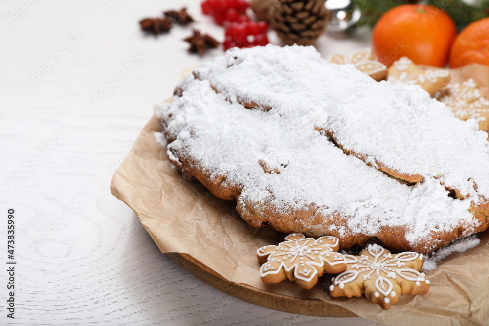 Traditional Christmas Stollen with icing sugar on white wooden table Traditional Christmas Stollen with icing sugar on white wooden table