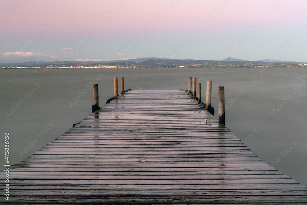 Naklejka premium Wooden footbridge with moorings for boats, over the Albufera de Valencia.
