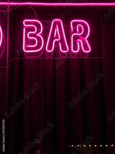Pink neon bar sign glowing in the dark