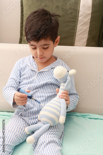 Close up of litle boy with diabetes injecting insulin. photo