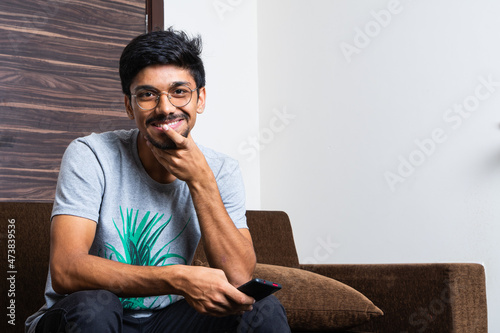 young teenage boy using mobile phone sitting on sofa © Anuj