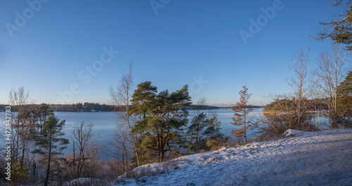 View point from a walkway with snow and an icy lake Mälaren a sunny pale winter day with snow in Stockholm