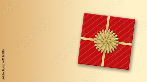 Red gift wrap square box with golden bow and ribbon