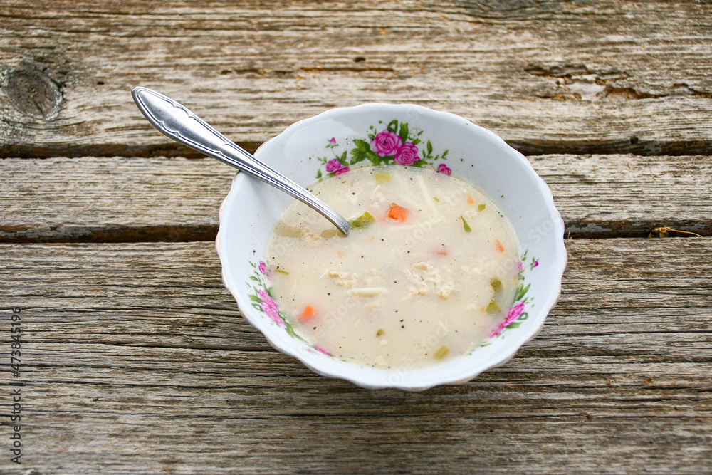 Home made chicken soup with noodles ,parsley and vegetables in white bowl . Healty soup Home made chicken soup with noodles ,parsley and vegetables in white bowl . Healty soup