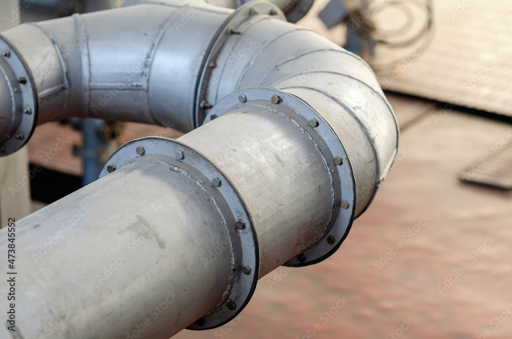 Part of a curved pipe. Connections on pipes. Bolts. Industry. Part of a curved pipe. Connections on pipes. Bolts. Industry.