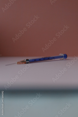 Pojedyncza strzykawka z igłą do szczepienia przeciwko Covid na pastelowym tle