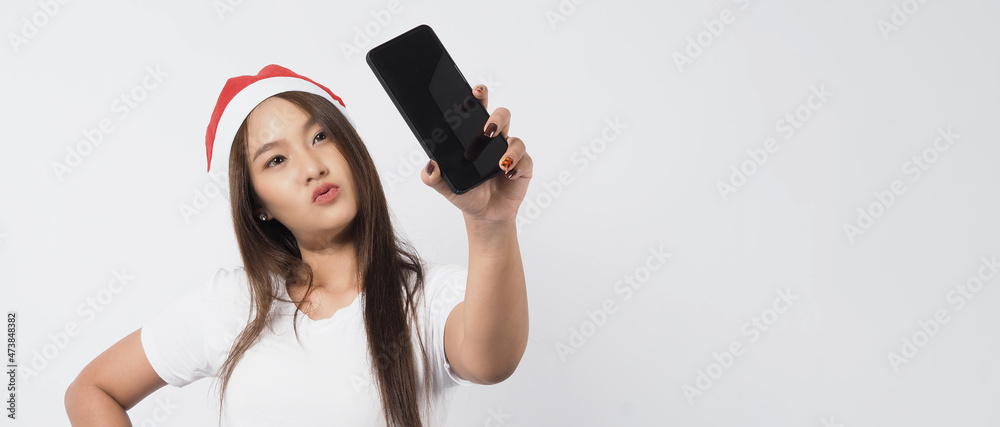 Naklejka premium Woman and smartphone. Asian woman with smartphone in hand which posing like selfie or video call for online celebration in Christmas and new year festival season. Teenage braces happy and smartphone.