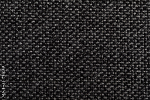 Black fabric texture. Furniture upholstery textiles. Embossed pattern. Woven fibers. The material is soft touch. Minimalism concept. High detail macro photography for backgrounds or wallpapers.