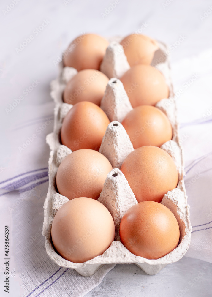 Chicken eggs in a cardboard stand on a gray background close-up, top view. Farmed organic food. Background with eggs in modern style
