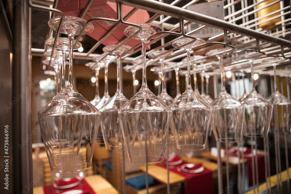 Close up of a stemware rack at restaurant full of clean glasses
