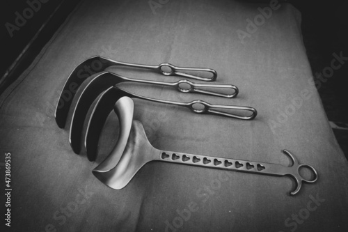 some various surgical abdominal retractors lie side by side on a green base photo