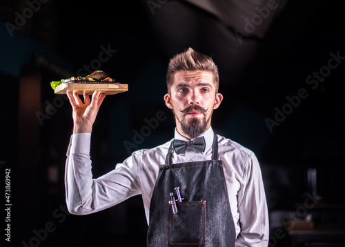 Charismatic steward helpfully holds plate with prepared dish at a festive event. photo