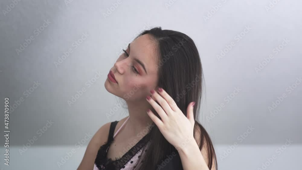 Lating girl in pajama combing her raven long hair