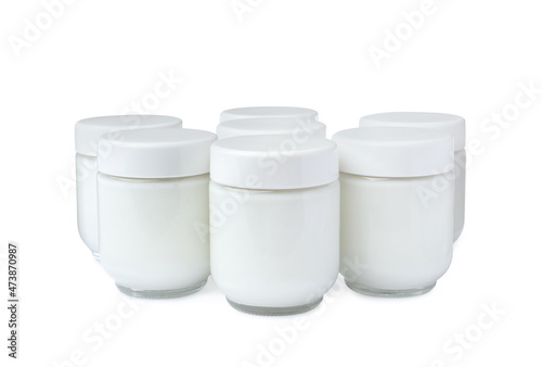 Glass jars with delicious homemade yogurt on white background