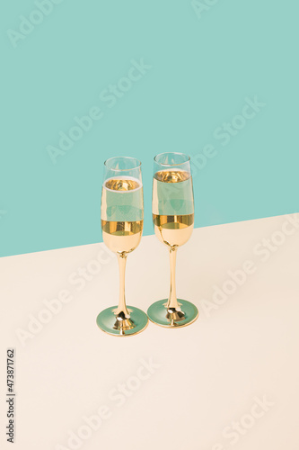 Celebration champagne glasses on a two tone colorful background. New Year celebration minimal concept	
 photo