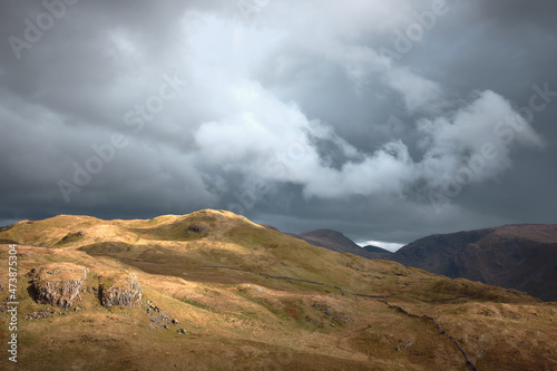 Delicate sunlit clouds above Cat Crag near Angle Tarn, Patterdale, Lake District, UK