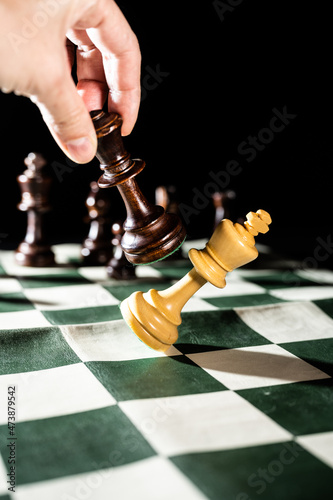 Playing chess on a foldable board. Close ups of some important pieces. 