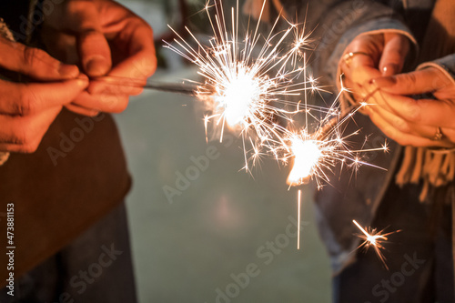 Lighting sparkler with friends. Festive mood celebration