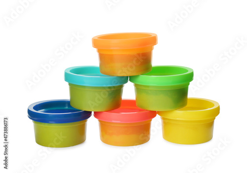 Plastic containers with colorful play dough on white background