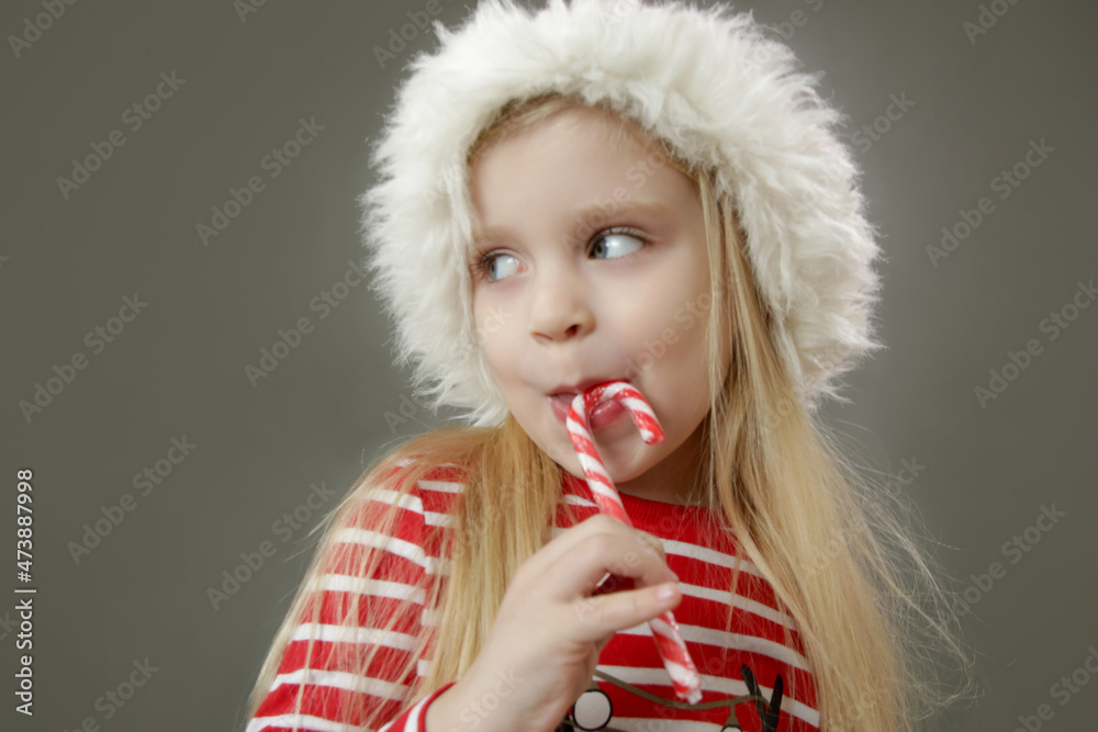 Studio portrait of 4 years old girl in Santa hat holding candy cane. It's holiday season!
Studio portrait of 4 years old girl in Santa hat holding candy cane. It's holiday season!