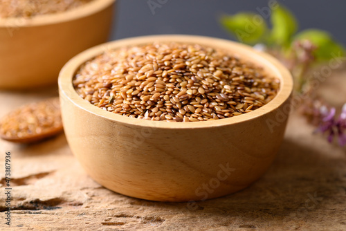 Close up of golden flax seed in bowl on wooden background