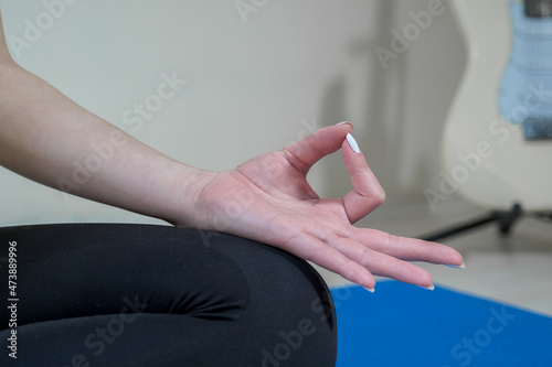 Cropped shot of an unrecognizable woman sitting on a yoga mat and meditating alone in her home