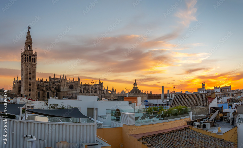 Obraz premium Sunset view from a rooftop overlooking the Andalusian city of Seville, Spain, with the Giralda Tower and the great Seville Cathedral in view over the skyline at early evening.