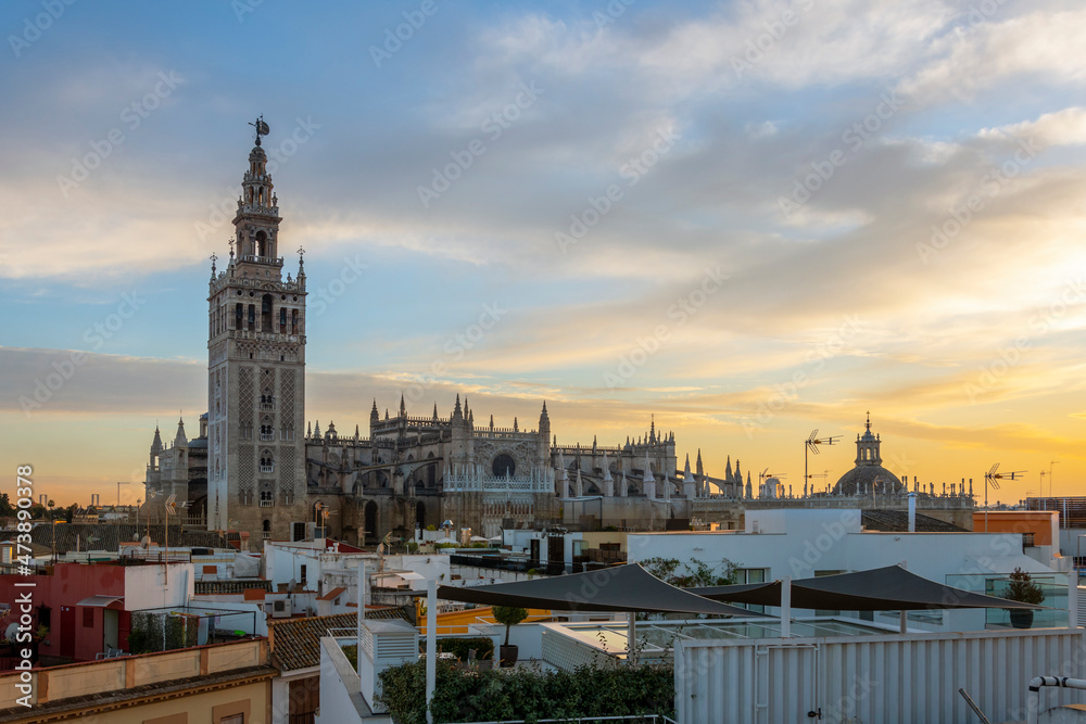 View from a rooftop of the Seville Cathedral and Giralda Tower at sunset in the Andalucian city of Seville in Southern Spain.