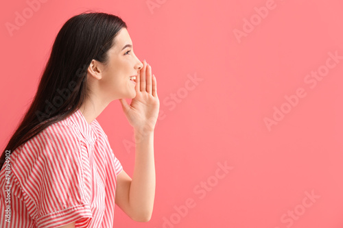 Young gossiping woman on color background photo