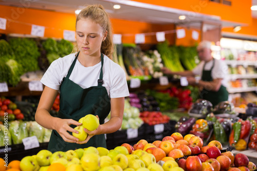 Obraz na plátně Fifteen-year-old girl who works part-time in a store as a trainee saleswoman put