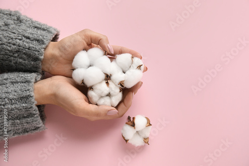 Woman holding cotton flowers on color table