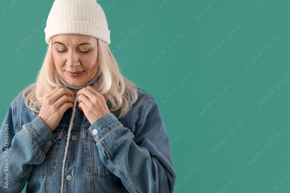 Beautiful mature woman in warm clothes on color background Beautiful mature woman in warm clothes on color background