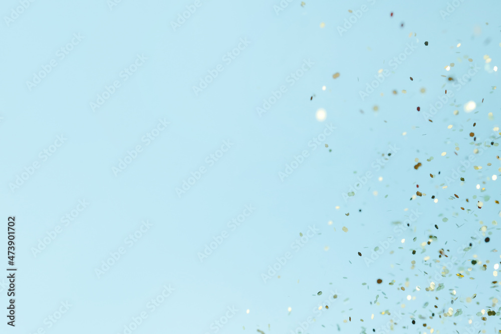 Flying confetti against blue background Flying confetti against blue background